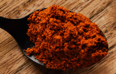 Photo of ground paprika on a spoon.
